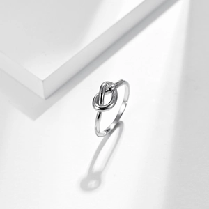 Minimalist silver stainless steel love knot ring with modern architectural shadows