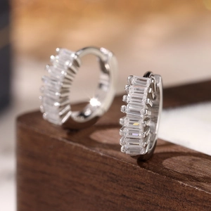 Macro shot of 925 silver hoop earrings with channel-set rectangular zircon stones