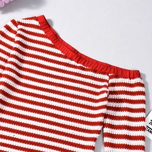 Detailed view of red and white striped knit top with textured wavy fabric and neckline