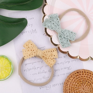 Detail of high-stretch nylon baby headbands with delicate lace plaid bows in soft colors