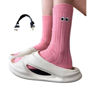Pink cotton slouch socks with eye embroidery detail shown with white slides on plain background