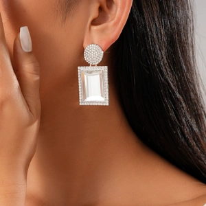 Dettaglio degli orecchini geometrici in argento con cristalli brillanti su modella