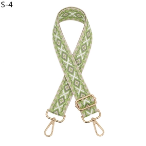 Detail of adjustable beige and green geometric fabric strap with gold metal hooks