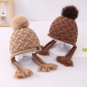 Winter knit baby hats with pom-poms, earflaps and tassels in khaki and brown colors
