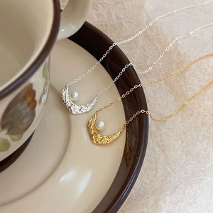 925 silver crescent moon pearl necklace in gold and silver finish on a coffee cup