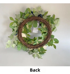 Detail view of the back showing natural rattan base and faux greenery of the wreath