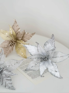 Détail de fleurs de Noël argentées et dorées avec paillettes et texture raffinée