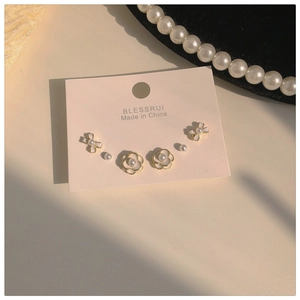 Detailed close-up of a three-pair earring set with camellia and pearl designs