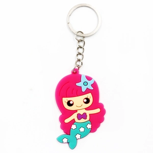 Close-up of PVC mermaid keychain with pink hair and green tail on silver metal ring