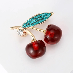 Cute cherry brooch with red resin fruit and golden leaves featuring turquoise rhinestones