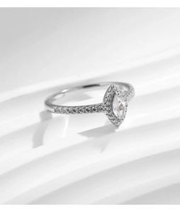Close-up of marquise-cut halo ring with side diamonds on silver metal band