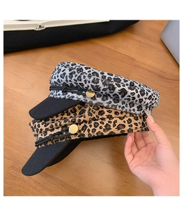 Detail of leopard print newsboy caps showing texture, brim and side metallic buckle decor