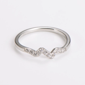 Macro detail of wave-shaped stainless steel ring featuring brilliant micro-set cubic zirconia