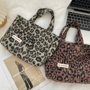 Detail of leopard print plush tote bag with branded woven label and soft fuzzy texture