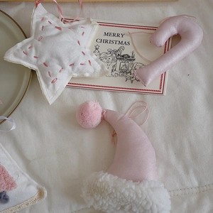 Pink and white fabric Christmas ornaments with stars, candy canes and Santa hats