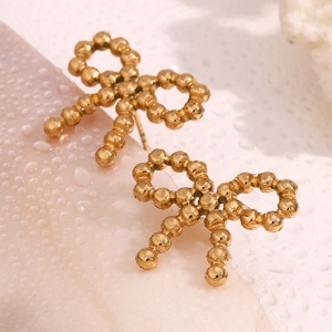 Macro view of gold plated stainless steel bow earrings with a unique beaded metal texture
