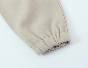 Vue détaillée du bas de jogging beige avec poignets élastiques et texture douce