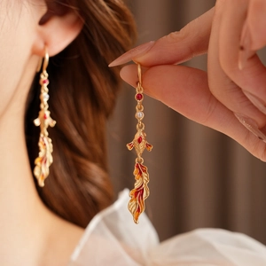 Close-up of vintage koi fish earrings with red enamel and golden finish on a model