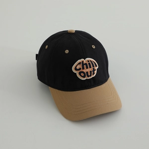 Detail of a two-tone baseball cap with Chill OUT embroidery and soft khaki brim