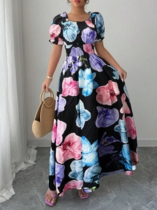 Détail d'une robe maxi fleurie avec manches bouffantes et taille élastique sur tissu noir