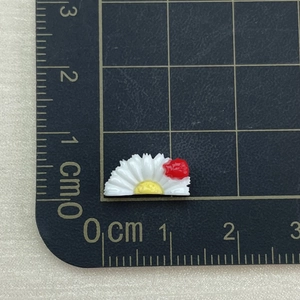 Mini resin white daisy charms with red ladybug detail on a measuring scale ruler