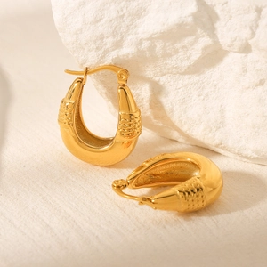 Polished 18k gold stainless steel teardrop earrings with woven texture on stone pedestal
