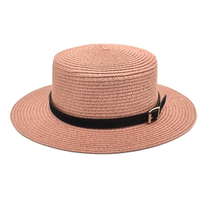 Detail eines rosa Strohhuts mit feinem Geflecht und schwarzem Gürtel mit goldener Schnalle