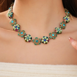 Close-up of vintage bronze flower necklace with colorful enamel and sparkling rhinestones