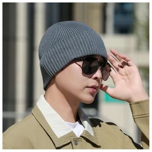 Détail d'un bonnet en maille gris foncé sur un mannequin au style urbain décontracté