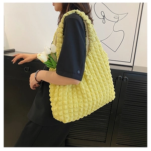 Detail of bright yellow puff tote bag with 3D textured pleats and large capacity