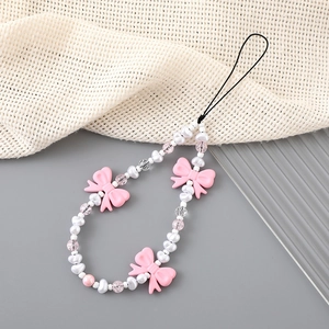 Bijou de téléphone avec nœuds roses et perles blanches sur dragonne noire