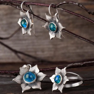 Parure de bijoux en argent avec pierres bleues sur des branches rustiques
