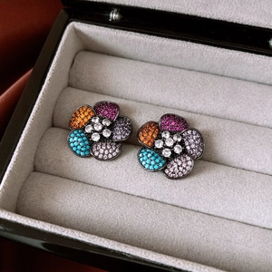 Macro detail of vintage flower stud earrings with multicolored pavé zircon stones