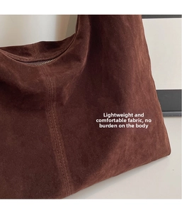 Detail of high-quality brown suede tote bag featuring smooth zipper and precision stitching