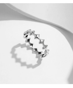 Macro shot of silver geometric star ring showing vintage industrial spikes and shadows
