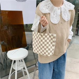 Detail of checkered corduroy handbag with vintage metal snap button for closure