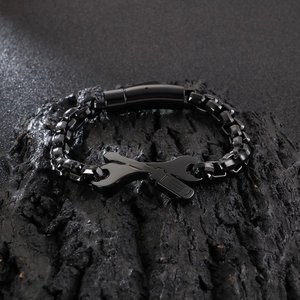 Detailed close-up of a black plated metal bracelet with wrench and screwdriver charms