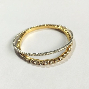 Close-up of flexible 2.0mm rhinestone bracelets in twisted gold and silver finishes