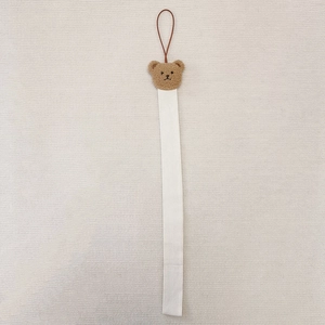 Hanging organizer for hair accessories with plush bear head and white fabric strap