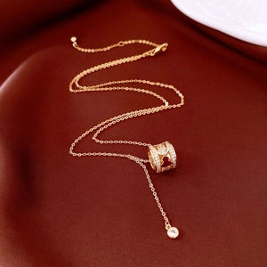 Macro shot of gold plated gourd pendant with sparkling white zircons and red heart patterns
