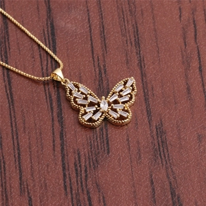 Minimalist gold butterfly pendant necklace with zircon gemstones on a wooden surface
