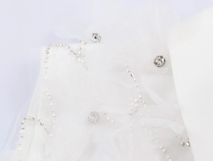 Gros plan sur tissu en maille de dentelle blanche avec perles argentées et strass