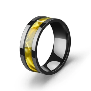 Detailed view of black polished ring with inlaid gold marble pattern on white background