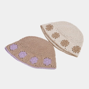 Detailed close-up of handmade crochet bucket hats with floral patterns in soft colors