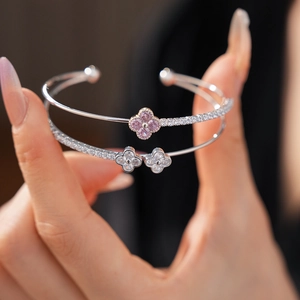 Close-up of double-layer open bracelets featuring zircon clover charms on the wrist