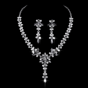 Close-up of luxury crystal bridal necklace and earrings set with shimmering floral details