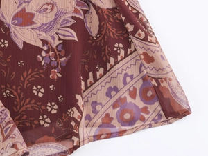 Detail of bohemian paisley print on burgundy chiffon fabric with soft pleats