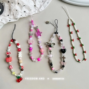 Detail view of handmade beaded phone straps featuring cherry, bear, and star charms