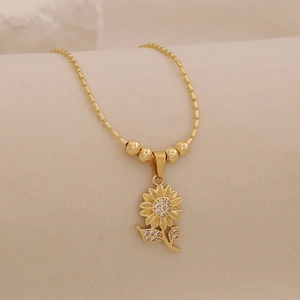 Close-up of 18K gold sunflower pendant necklace with sparkling crystal inlay detailing