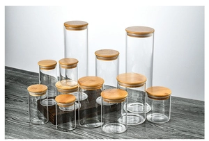 Set of 10 glass food storage jars with bamboo lids in various sizes on wooden table